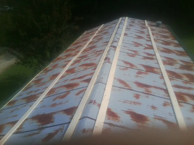 Rusted metal roof panels with new wood purlins before replacement — Storm Damage Roof Repair in Rising Sun by Roofing Brothers